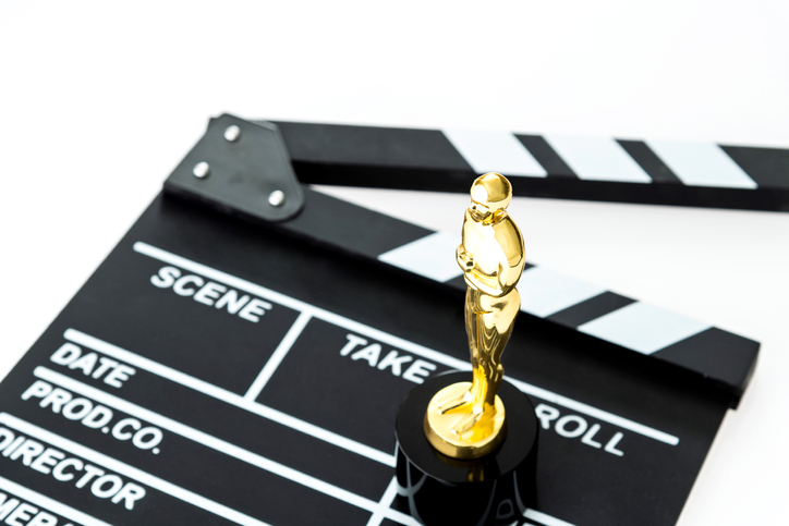 Film slate and golden award on white background