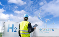 Engineer with tablet computer on a background of Green Hydrogen factory