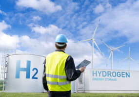 Engineer with tablet computer on a background of Green Hydrogen factory