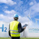 Engineer with tablet computer on a background of Green Hydrogen factory