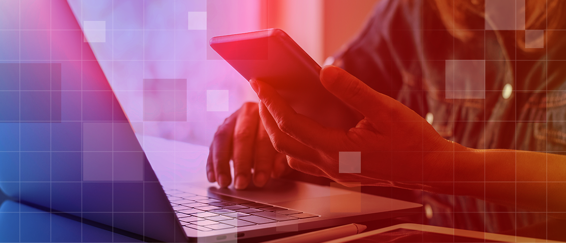 T9_PM2030_Democratisation 2 A person is reading their phone while sitting in front of a laptop