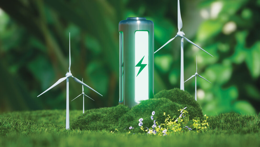 Photo of a green eco-battery surrounded by forestry and windturbines.