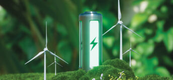 Photo of a green eco-battery surrounded by forestry and windturbines.