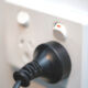 White power point outlet socket (3 pin Australian type) with switch on and black plug inserted