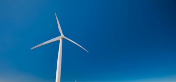 Wind turbines along ocean shore sustainable and renewable energy landscape view