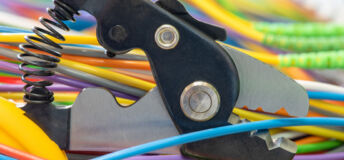 A photo of a cable cutter just about to cut a data cable