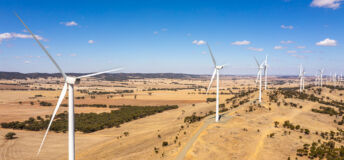 Wind Farm with blue sky in an open paddock.