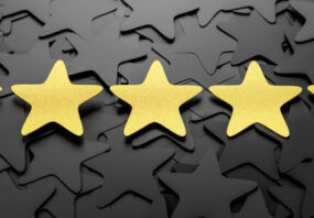 Five gold stars in a line on a background of black stars