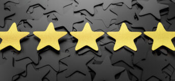 Five gold stars in a line on a background of black stars