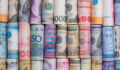 Large funds make all the difference in APACโs infra fundraising Closeup rolled of variety banknote and multi currency around the world. Exchange rate and Forex investment concept.-Image.