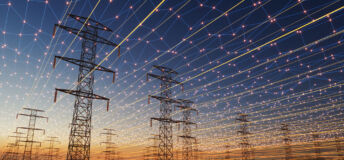 A futuristic visualization of high-voltage transmission towers beneath a digital energy grid. Glowing network lines and light points span across the sky, symbolizing smart grid technology, connectivity, and the modernization of electrical infrastructure at sunset.