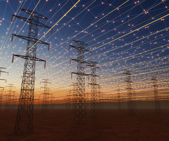 A futuristic visualization of high-voltage transmission towers beneath a digital energy grid. Glowing network lines and light points span across the sky, symbolizing smart grid technology, connectivity, and the modernization of electrical infrastructure at sunset.
