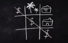 A game of naughts and crosses on a blackboard, but with dollar signs making a diagonal, with a picture of palm trees and a hotel in other squares