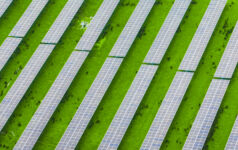 Rows of solar panels installed across farmland, illustrating the connection between renewable energy and rural landscapes, where technology and agriculture work together for a sustainable future.