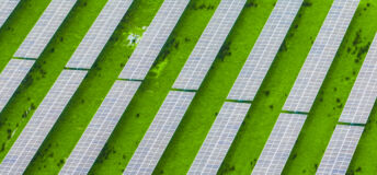 Rows of solar panels installed across farmland, illustrating the connection between renewable energy and rural landscapes, where technology and agriculture work together for a sustainable future.